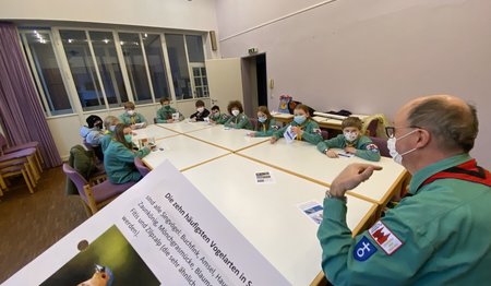 Eine Gruppe Pfadfinder sitzt in einem Raum und lernt. 