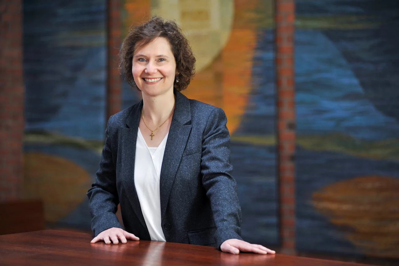 Eine Frau steht lächelnd in einem Raum