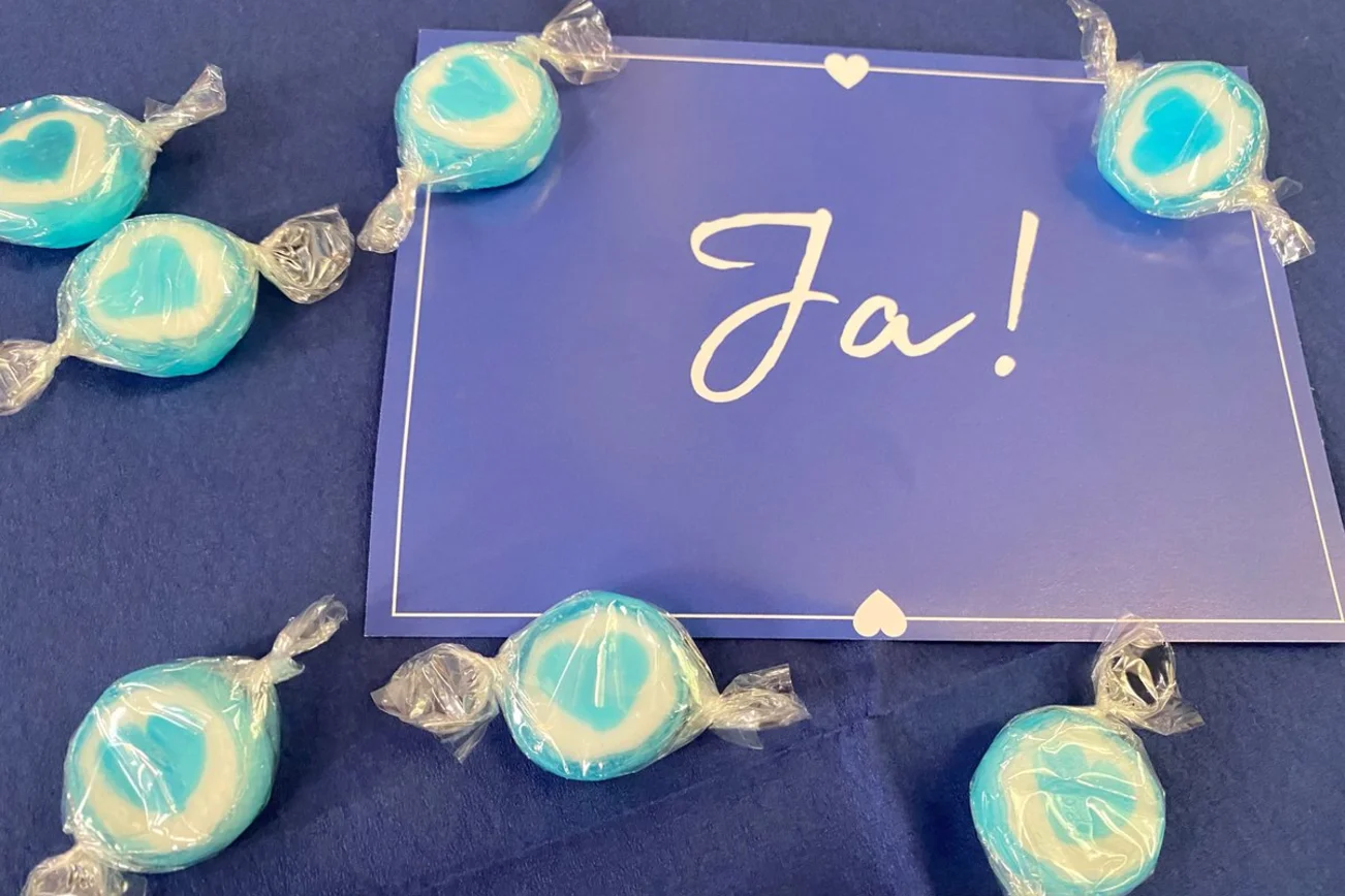 Eine Postkarte und Bonbons im Herzform