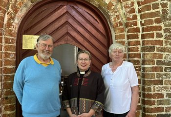 Drei Personen vor dem Eingang einer Kapelle. - Copyright: Annkathrin Bornholdt