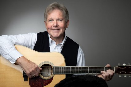 Mann lächelt mit einer Gitarre auf dem Schoß. - Copyright: Christina Opeldus
