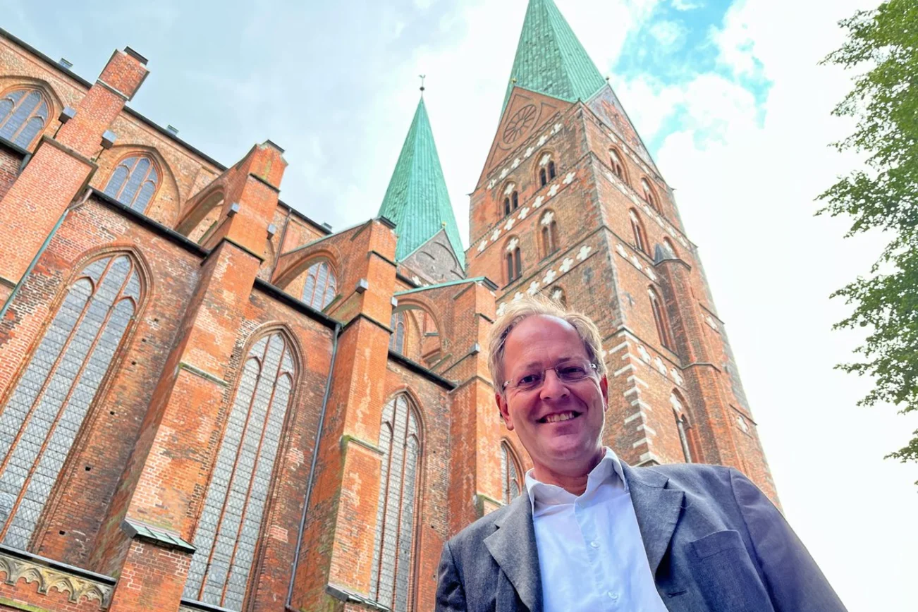 Ein Mann steht vor einer Kirche 