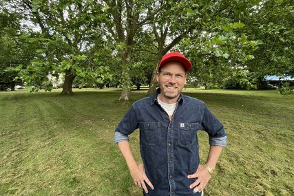 Junger Mann mit Basecap steht in einem grünen Park. - Copyright: Katharina Micheel