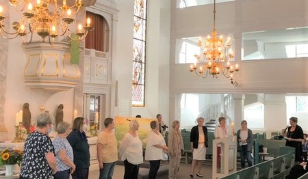 Ehrenamtliche Lydia-Frauen stehen vor dem Altar in der St. Petri Kirche