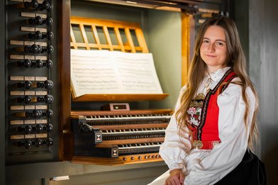 Die norwegische Organistin Victoria Ulriksen in landestypischer Tracht am Spieltisch einer Orgel - Copyright: Levent Ultanur