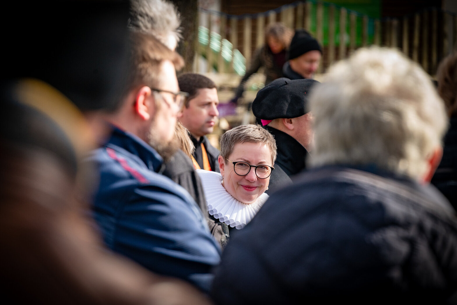 Eine Frau durch eine Menschengruppe hindurch fotografiert