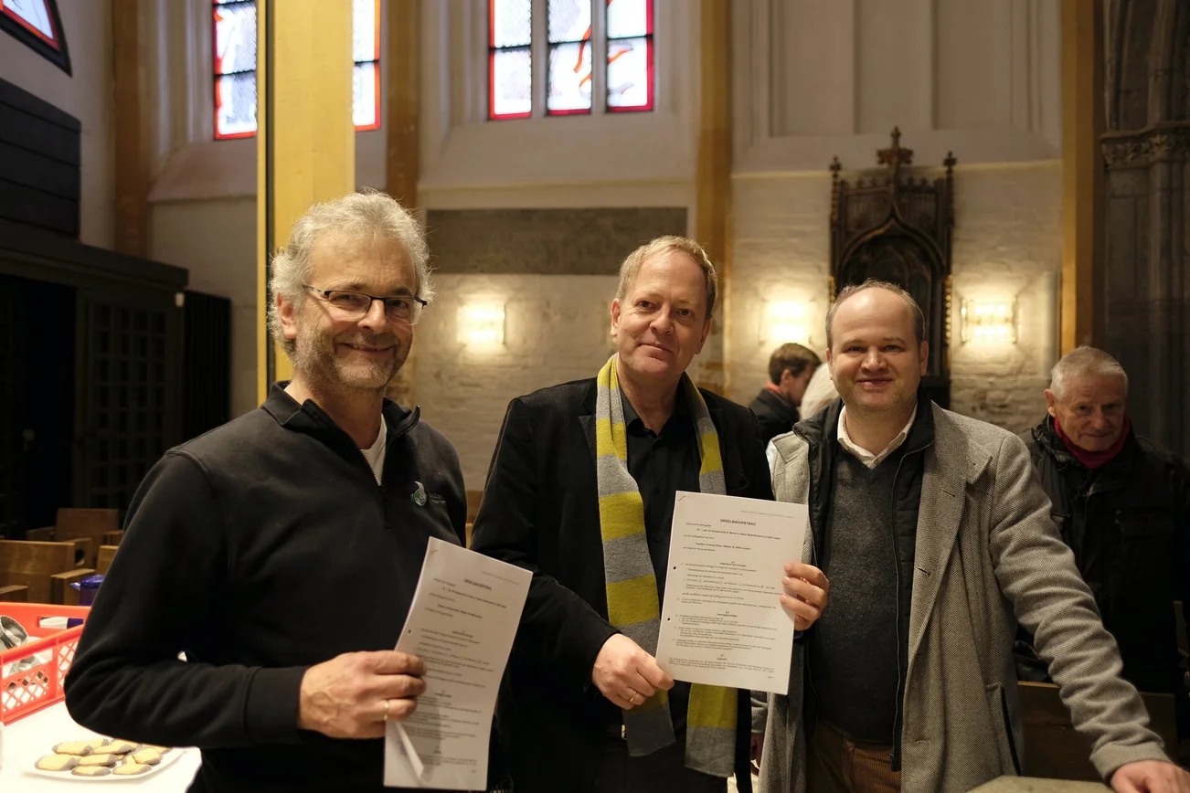 Gruppenfoto mit drei Männern in einer Kirche