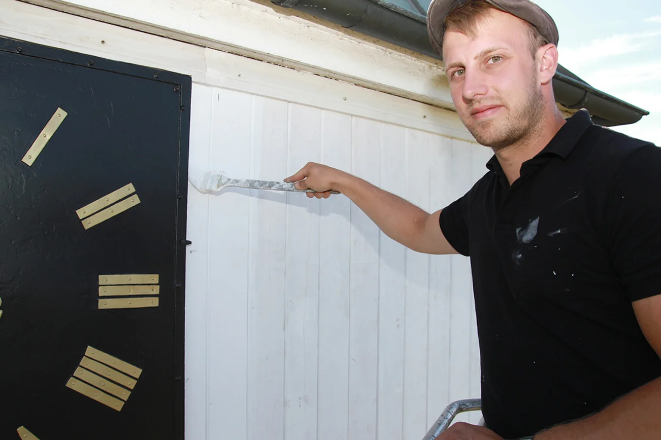 Pascal Schwarz (26) bringt die weiße Farbe auf dem Kirchturm auf.