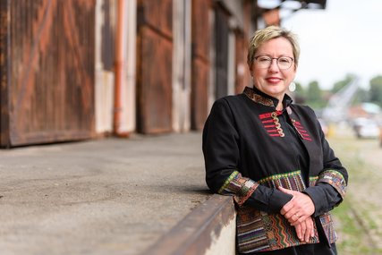 Frau lehnt sich entspannt an eine Kante - Copyright: Guido Kollmeier