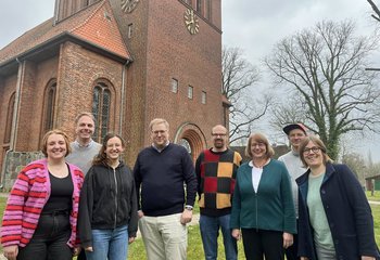 Eine Gruppe Frauen und Männer steht vor einer Kirche - Copyright: Annkathrin Bornholdt