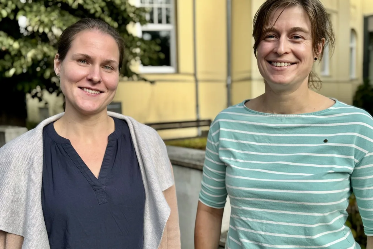 Zwei Personen lächeln in die Kamera