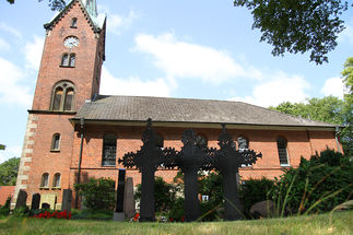 Drei Metallkreuze vor der St.-Nikolai-Kirche in Hohenhorn