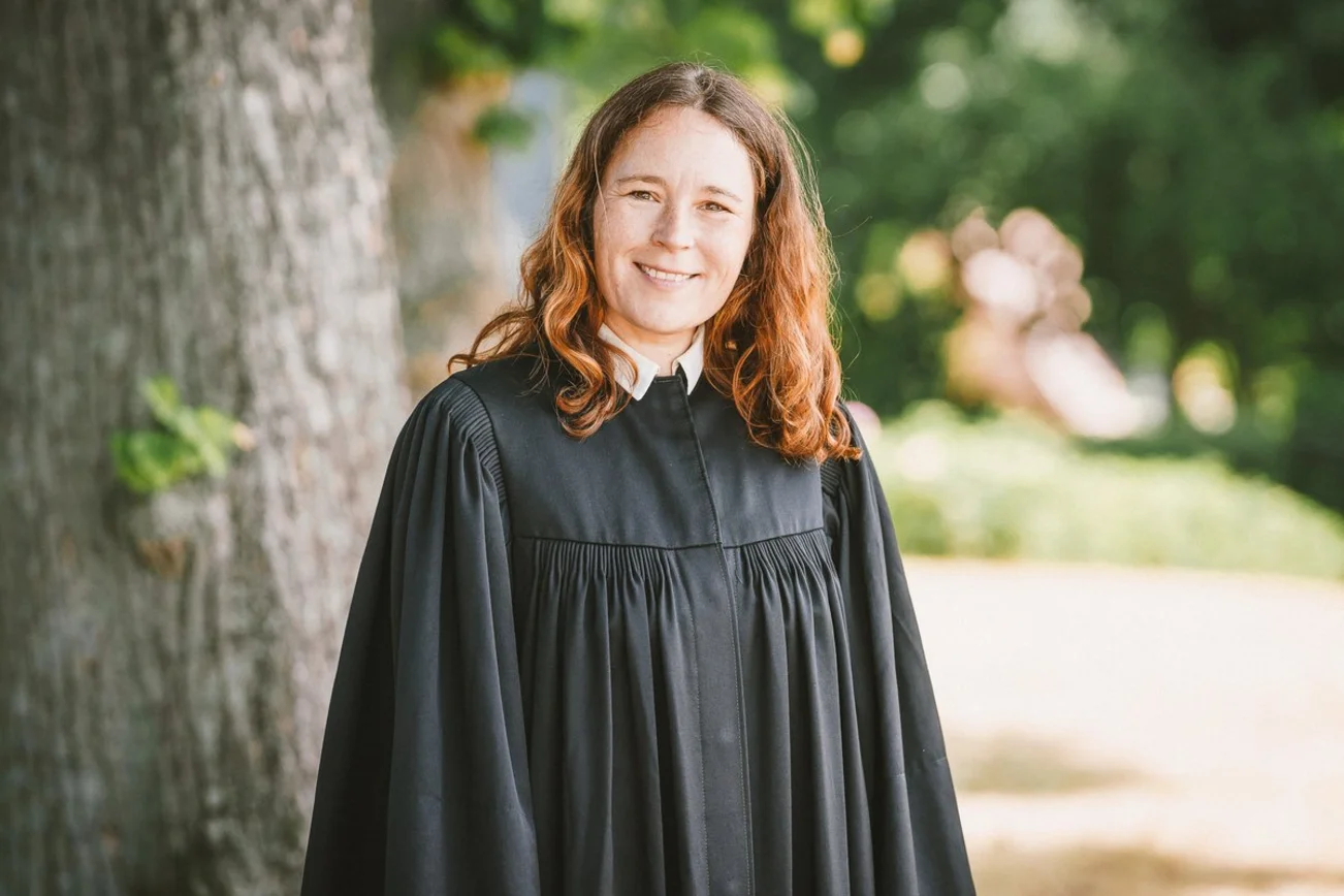 Pastorin Mareike Hasen im Talar vor einem Baum