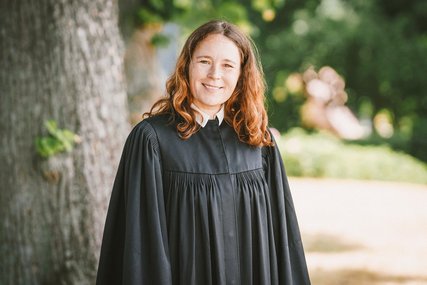 Pastorin Mareike Hasen im Talar vor einem Baum - Copyright: Guido Kollmeier
