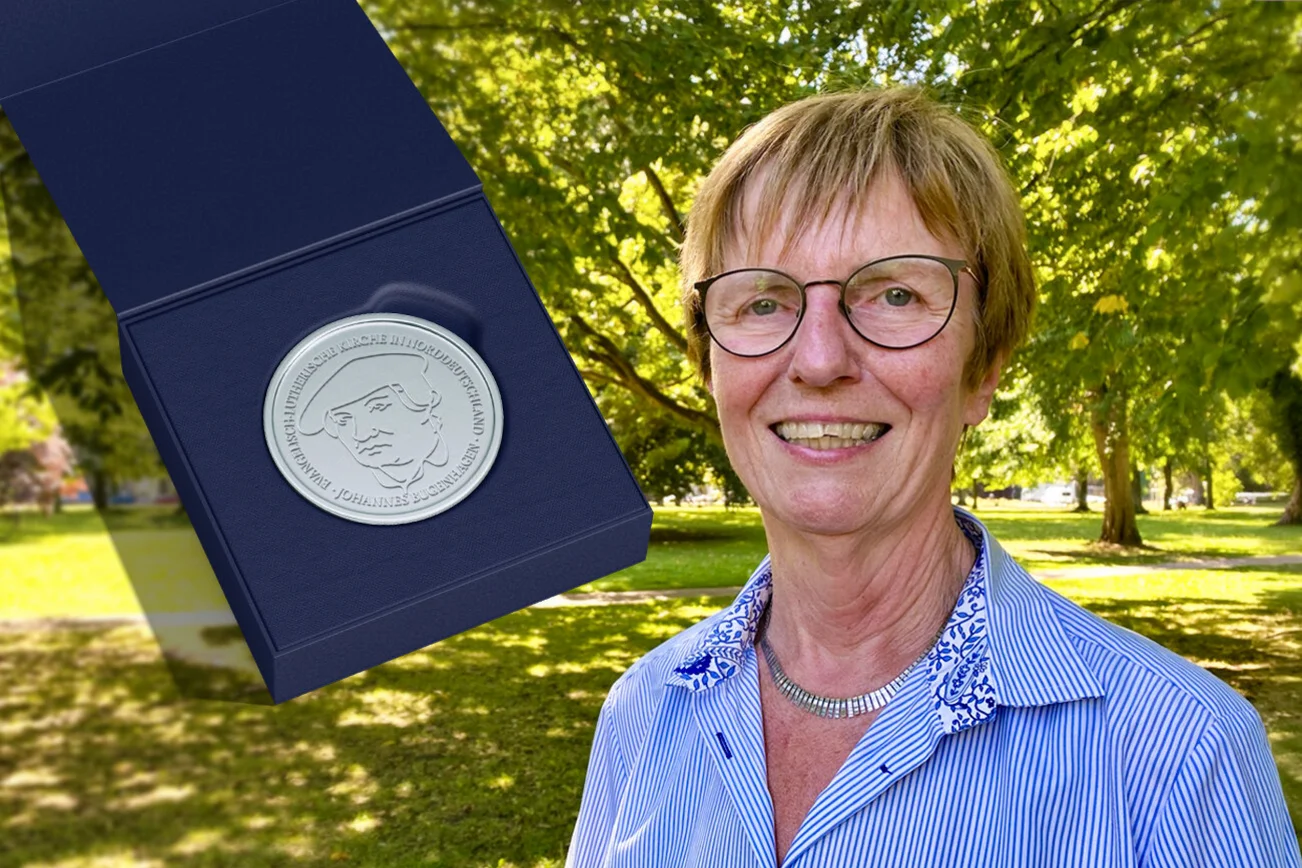 Eine Frau zeigt eine Medaille