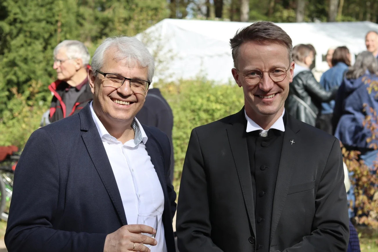 Zwei Männer lächeln in die Kamera.