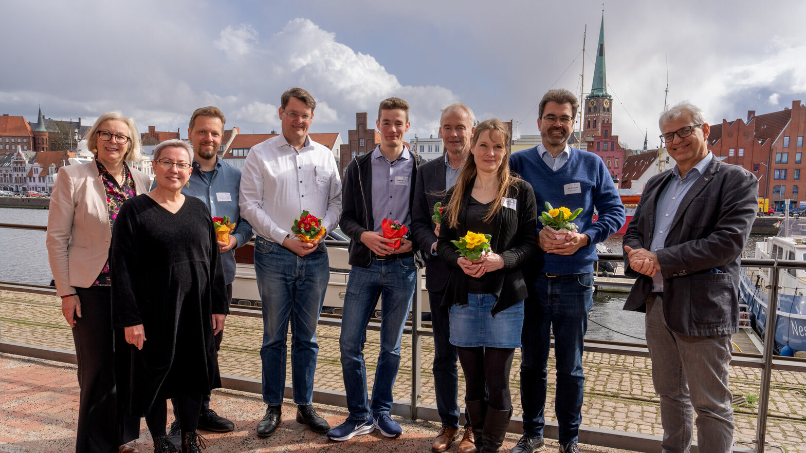 Menschen vor einer maritimen Kulisse. 