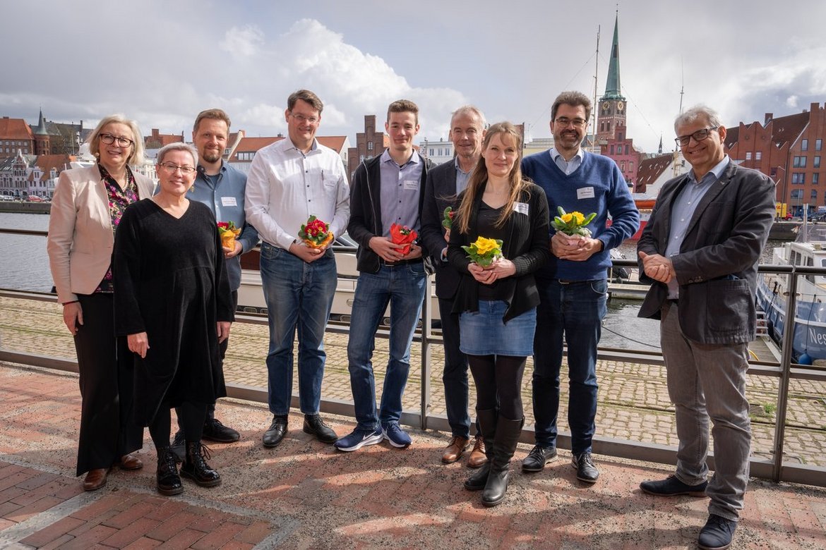 Menschen vor einer maritimen Kulisse. 