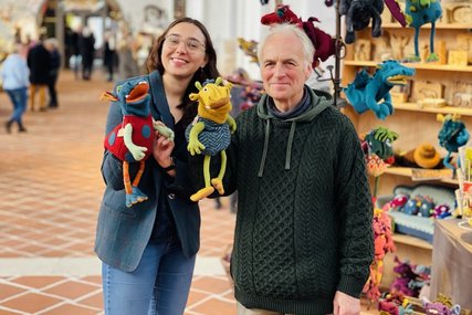 Pastorin Lilly Schaack und Marktleiter Frank Peschlow sind mit Handpuppen in der St. Petri-Kirche zu sehen und lächeln in die Kamera. - Copyright: Steffi Niemann