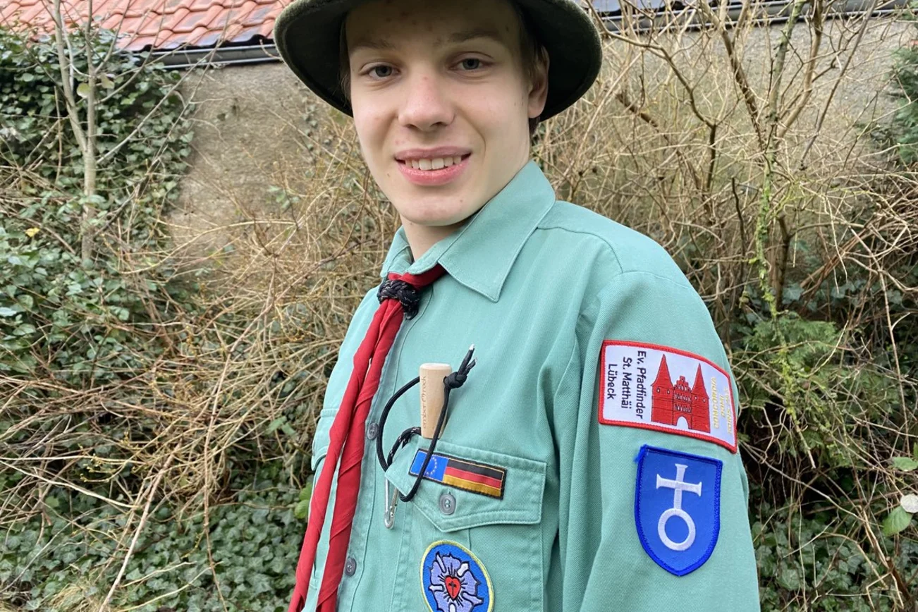 Ein junger Pfadfinder zeigt die Abzeichen seines Stammes. 