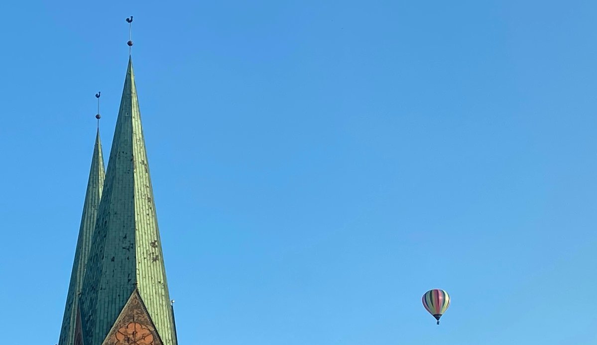 Turn einer Kirche mit zwei Heißluftballons