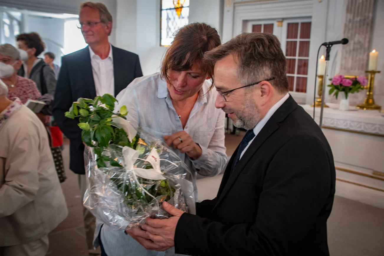 Eine Frau überreicht ein Geschenk. 