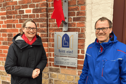 Zwei Menschen stehen lächelnd vor dem Eingang einer Kirche - Copyright: Mathias Stanierowski