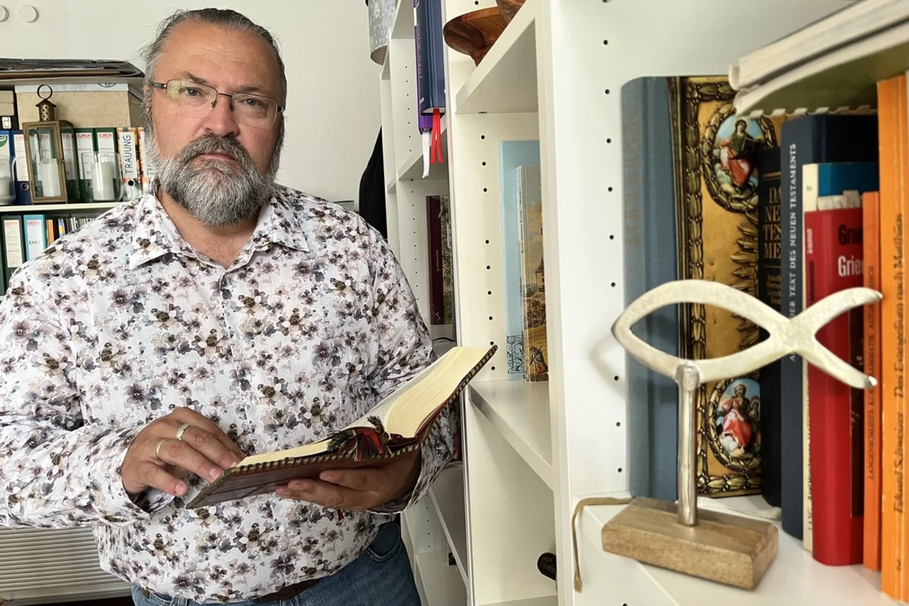 Ein Mann steht an einem Buchregal