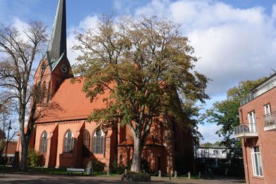 Kirchengebäude mit Bäumen - Copyright: Ev.-Luth. Kirchengemeinde Schwarzenbek