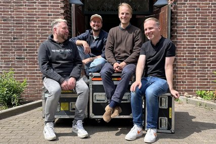 Vier Männer sitzen vor einer Kirche auf Technik-Containern. - Copyright: Ekklesia Elektronika