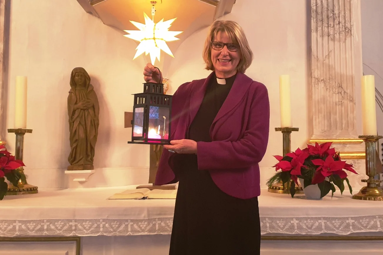 Eine Frau hält einen Kerzenleuchter, im Hintergrund der Altar der Ratzeburger Petrikirche und ein Herrnhuter Stern.