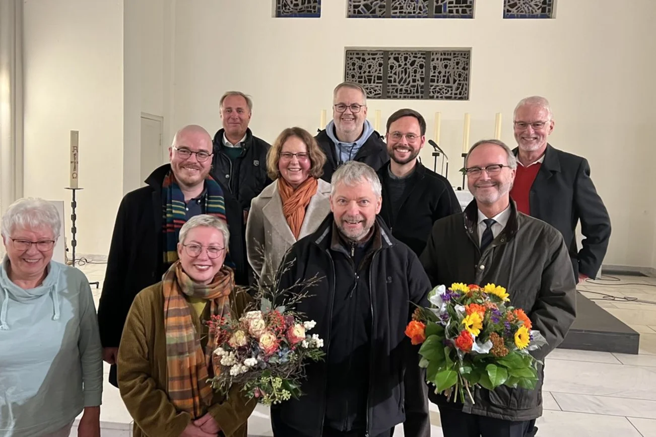 Eine Gruppe fröhlicher Menschen steht in einer Kirche.