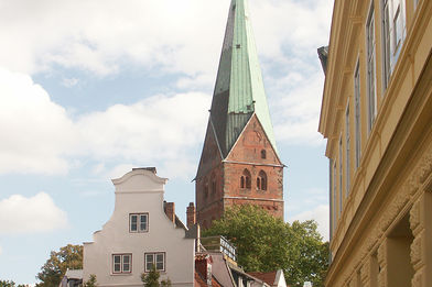 Der Turm der St.-Aegidien-Kirche ragt über die Lübecker Dächer - Im Vordergrund gabeln sich zwei Straßen - Copyright: Ev.-Luth. Kirchenkreis Lübeck-Lauenburg