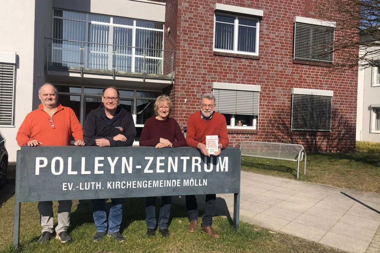 Vier Personen schauen in die Kamera