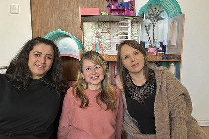Drei Frauen sitzen vor einem großen Puppenhaus. - Copyright: Annkathrin Bornholdt