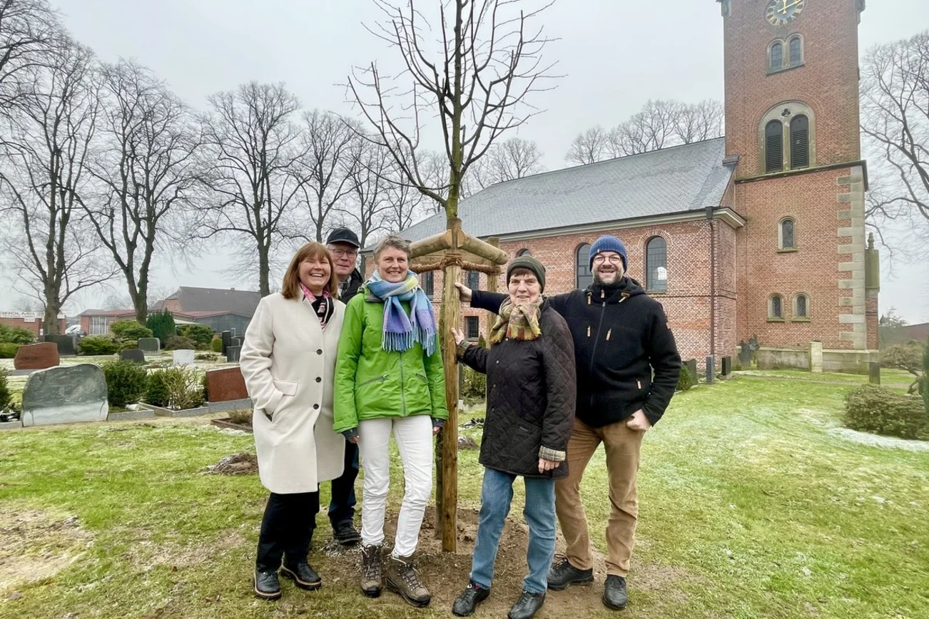 Menschen stehen auf einem Friedhof