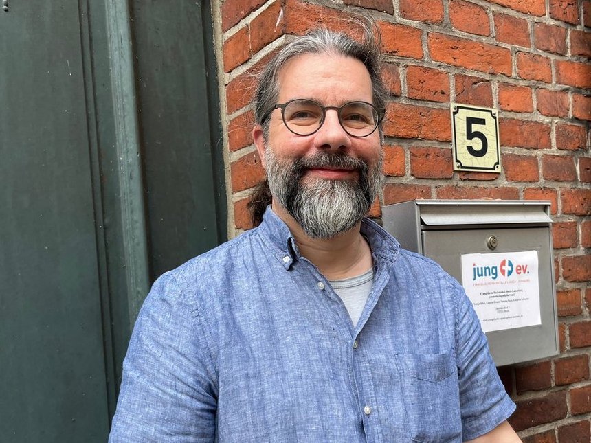 Mann schaut lächelnd in die Kamera