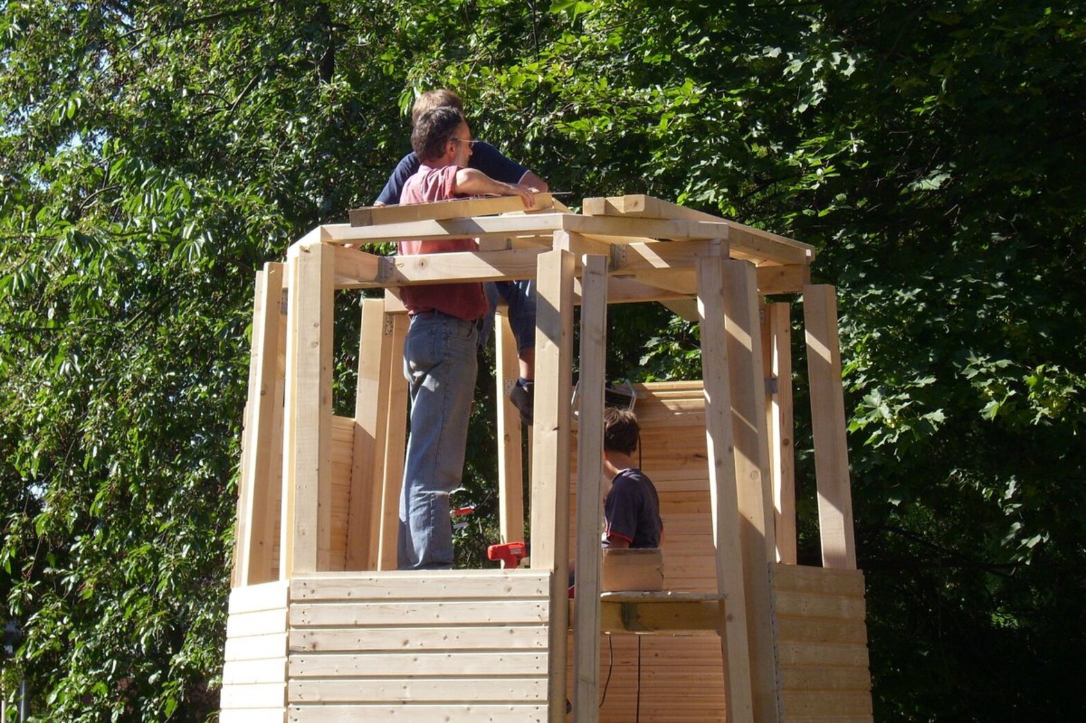 Zwei Männer arbeiten auf einem Holztturm.