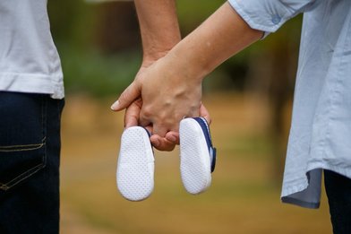 Hände von Mann und Frau die Babyschuhe in der Mitte halten - Copyright: Bruna_Bruna_pixabay_son-1910304_1920