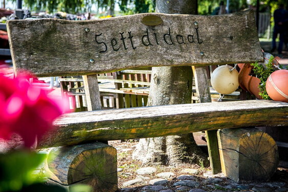 Holzbank mit plattdeutscher Schrift: Sett di daal - Copyright: Tobias-Albers Heinemann