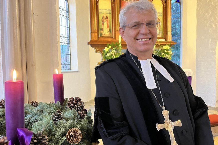Ein Mann steht in einer Kirche an einem Adventskranz - Copyright: Bastian Modrow
