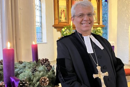 Ein Mann steht in einer Kirche an einem Adventskranz - Copyright: Bastian Modrow