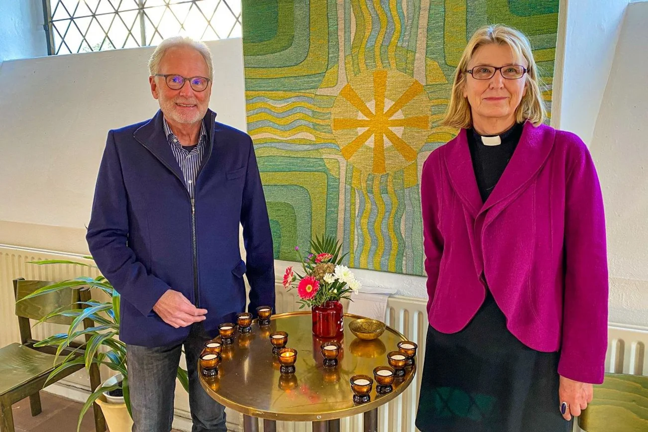 Zwei Personen stehen in einer Kirche. 