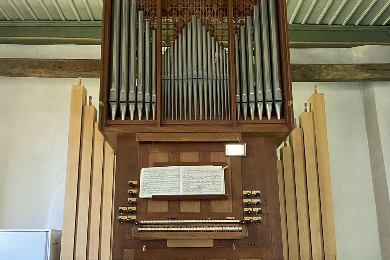 Eine Kirchenorgel mit Notenblättern auf dem Pult.