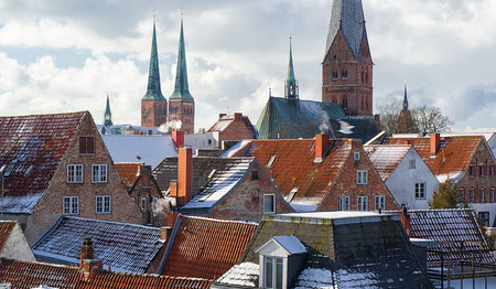 Leicht schneebedeckte Dächer Lübecks, im Hintergrund Der Dom und St. Aegidien