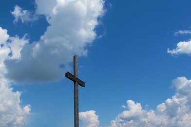 Kreuz vor einem überwiegend blauen Himmel - Copyright: Joujou  / pixelio.de