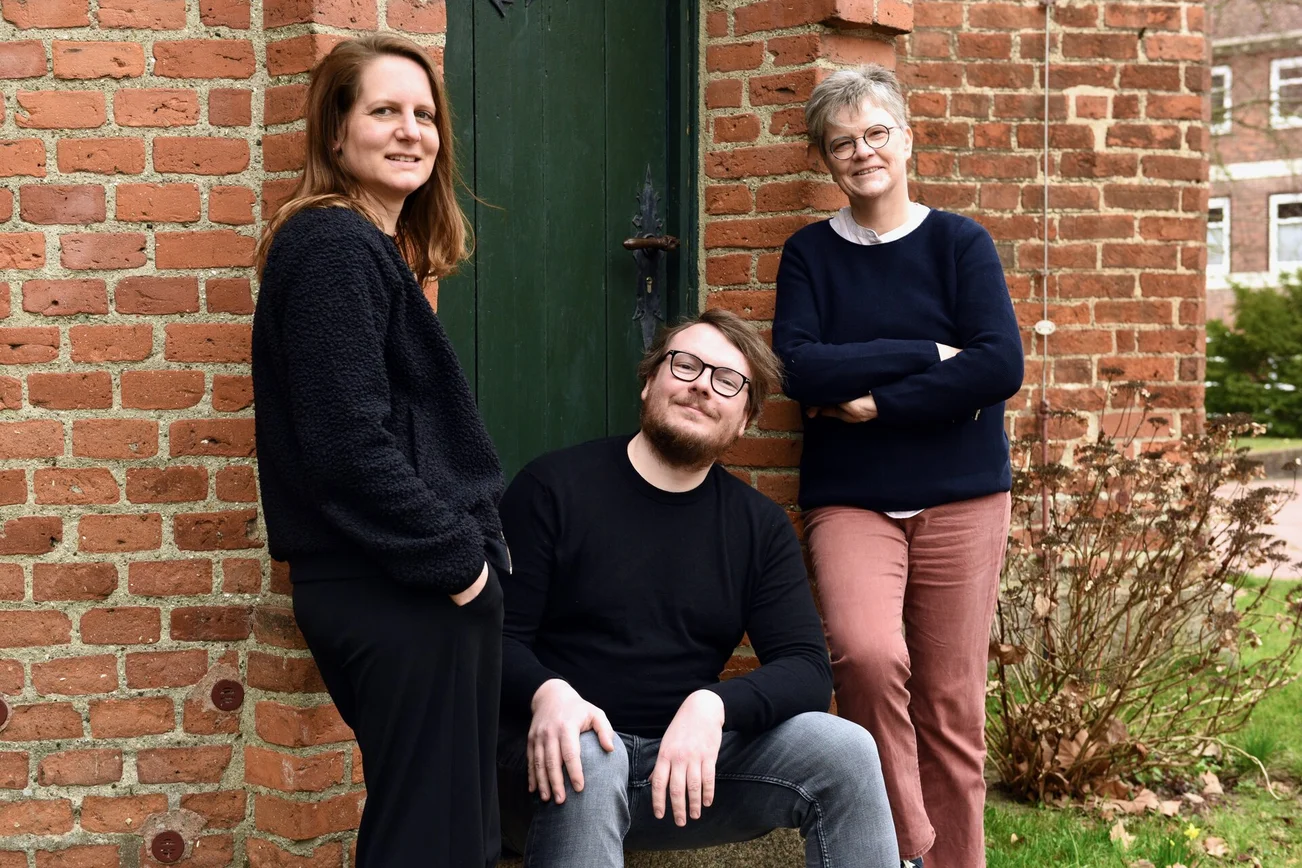 Drei Personen schauen in die Kamera 