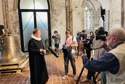 Ein Pastor steht vor Kameras in einer Kirche.  - Copyright: Steffi Niemann