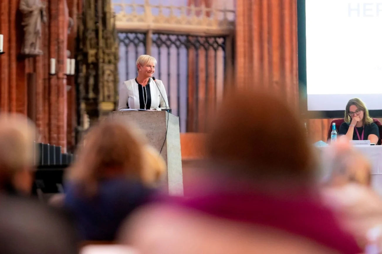 Eine Frau am Rednerpult in einem Kirchraum.