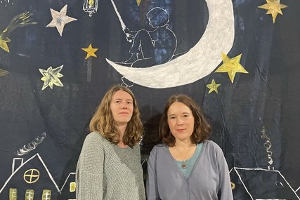 Zwei Frauen stehen vor einem Tuch mit Mond und Sternen. - Copyright: Annkathrin Bornholdt